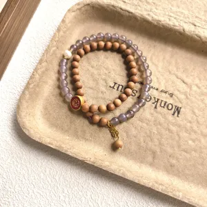 Gros plan détaillé de bracelets double couche en bois de santal et agate avec pendentif.