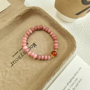 Détail de bracelet en perles abaque de quartz rose, bijou doux avec des accents dorés.
