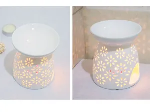 Bruciatore di oli essenziali in ceramica bianca con motivo floreale traforato per aromaterapia.