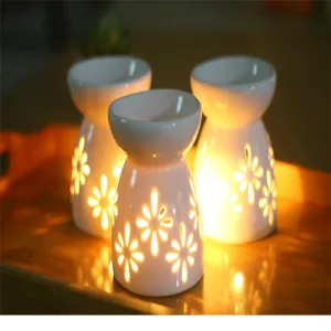 Detail van keramische geurbrander met bloemmotief en warm gloeiend licht in de kamer.