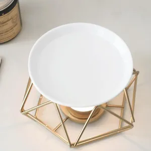 Detailed close-up of a creative gold iron aromatherapy oil burner with a white ceramic dish.