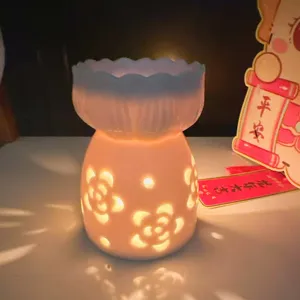 White ceramic essential oil burner with hollow flower pattern for home relaxing aromatherapy.