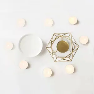Golden geometric iron aroma burner with ceramic dish and tea candles for home SPA decor.