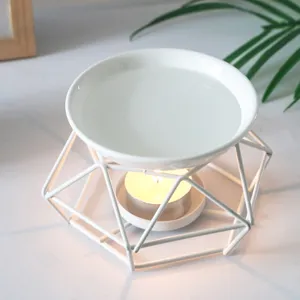 White ceramic essential oil burner with geometric metal frame for aromatherapy relaxation.