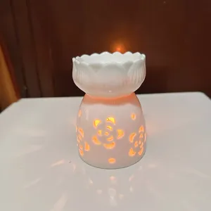 Ceramic aromatherapy burner detail view, hollow floral design for cozy home fragrance and essential oils.