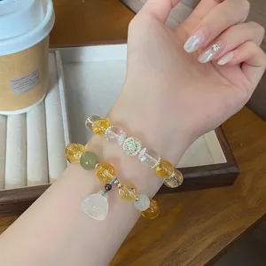Vue détaillée de bracelets de perles en cristal à double rang avec un pendentif lotus.
