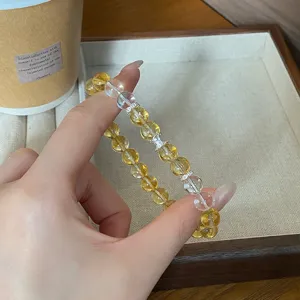 Bracelet de perles en citrine et cristal clair avec intercallaires métalliques, détail élégant.
