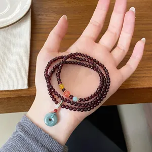 Gros plan détaillé du bracelet multi-tours en grenat rouge foncé avec une boucle de sécurité.
