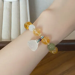 Gros plan d'un bracelet en cristal de style chinois avec pendentif lotus, détail de bijoux.