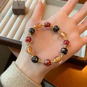 Detailed shot of Chinese style colorful crystal glass beaded bracelet with gold spacers.