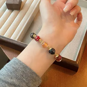 Chinese style multi-color glass and crystal bead bracelet with delicate gold spacer charms.