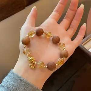 Chinese style sandalwood citrine crystal beaded bracelet with gold lock charm detail view.