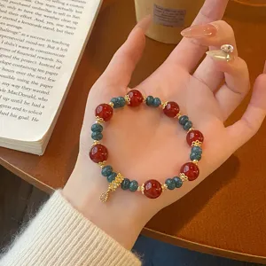 Retro Chinese red agate elastic bracelet with blue crystal and gold accents, exquisite detail view