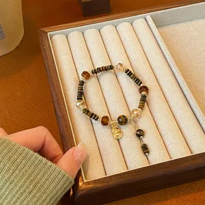 Bracelet de perles en œil de tigre rétro avec pendentif gourde dorée pour les femmes.