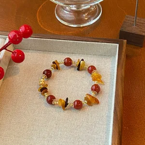 Close up detail view of a Chinese style beaded bracelet with red agate and yellow crystal.