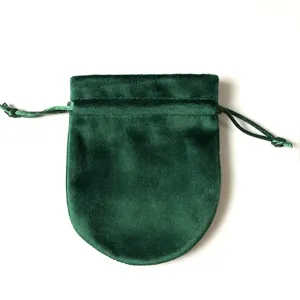 Gros plan sur la pochette à bijoux en velours vert foncé avec cordon de serrage.
