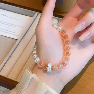 Gros plan de bracelet de perles en agate carnéole et perles avec entretoise en métal élégante.