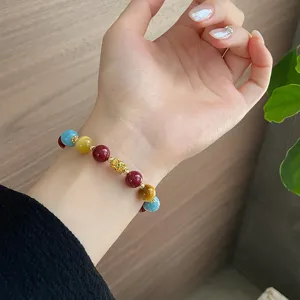 Primo piano dettagliato di un braccialetto colorato in stile etnico indossato al polso.