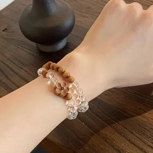 Close-up detail of double circle natural crystal and wooden bead bracelet worn on wrist.