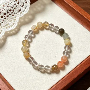 Close-up detail of multi-color rutilated quartz bracelet, showing natural gemstone beads.