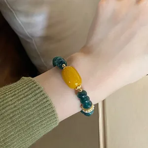 Exquisite Chinese style gemstone bracelet detail featuring yellow agate and green chalcedony beads.