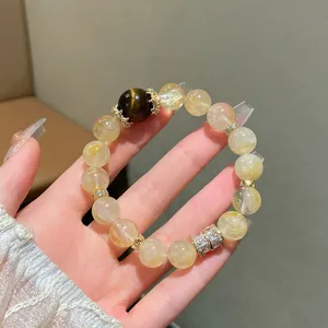 Detailed close-up of the natural yellow quartz and tiger eye gemstone beaded bracelet with rhinestones.