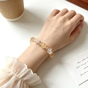 Detailed close-up of natural crystal beaded bracelet worn on wrist, elegant design.