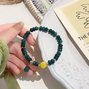 Detailed view of vintage green chalcedony and yellow agate beaded bracelet with cute charm.