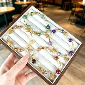 Colorful crystal gemstone beaded bracelets set with delicate leaf pendants and gold metal spacers.