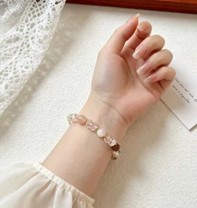 Detailed view of the natural crystal beaded bracelet worn on wrist, elegant jewelry design style.