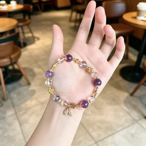 Exquisite crystal beaded bracelet detail, featuring amethyst and gold-leaf pendant charms.