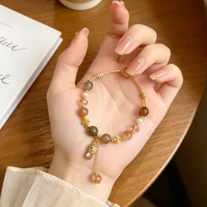 Detailed view of retro crystal bracelet featuring multi-color rutilated quartz and pixiu charm.