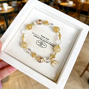 Charming natural crystal beaded bracelet with exquisite golden leaf pendant, elegant detail view.
