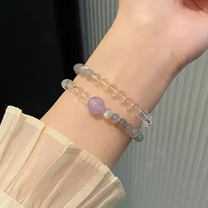 Close-up detail of multi-color crystal beaded double bracelets sparkling on a delicate wrist.