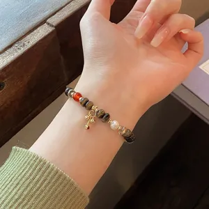 Détail en gros plan du bracelet de perles vintage chinois avec agate œil de tigre et gourde.