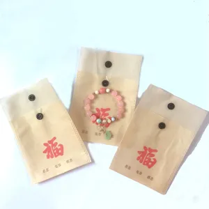 Bracelet de perles rose doux avec sacs d'emballage cadeau non tissés avec texte.