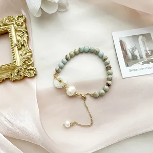 Detailed close-up of exquisite beaded bracelet with natural stones and elegant pearl charms.