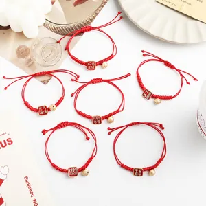 Rote geflochtene Seilarmbänder mit süßen Glocken und chinesischen Glückszeichen als Geschenk.