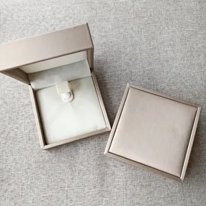 Élégant coffret cadeau carré pour bijoux avec plateau intérieur pour petits accessoires.