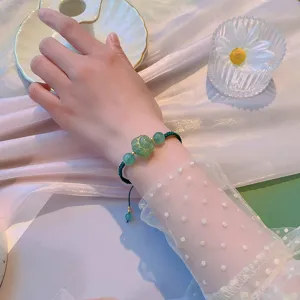 Joli bracelet tressé vert fait main avec un adorable bijou perles patte de chat.