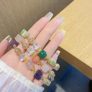 Handcrafted multi-gemstone crystal beaded bracelet with elegant gold-tone metal spacer charms.