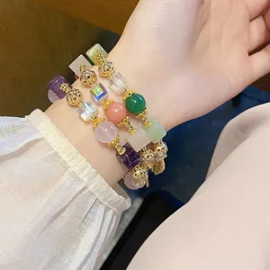 Detailed view of a multi-layer gemstone beaded bracelet with crystal and gold accents.