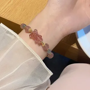 Nahaufnahme Detail eines süßen Kristall Erdbeerquarz und Graumondstein Bären Armbands.