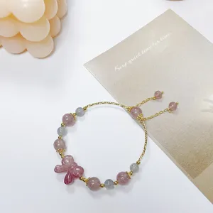 Nahaufnahme des süßen Erdbeerquarz und Graumondstein Armbands mit feinem Schleifenanhänger.