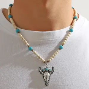 Close-up detail shot of vintage ethnic style turquoise bull skull pendant beaded necklace.