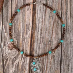 Handmade wooden bead necklace detail with turquoise stones and vintage silver pendant.