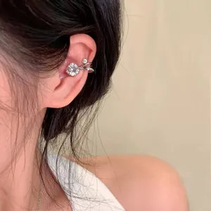 Primo piano dettaglio di un cuffino auricolare argento minimalista con zirconi luminosi.