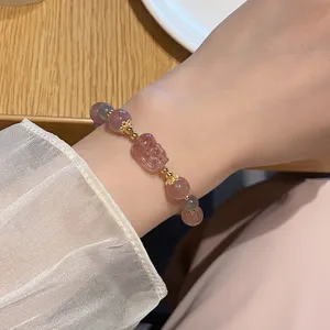 Nahaufnahme des süßen Erdbeerquarz und grauen Mondstein Armbands am Handgelenk.