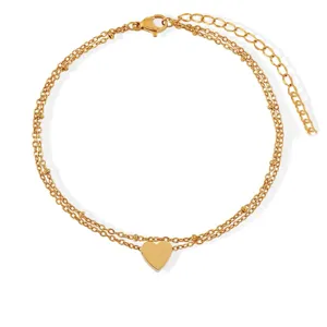 Detailed view of the double-layer gold anklet with small beads and a sleek heart pendant.