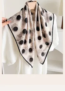 Detailed close-up of a vintage polka dot square scarf, featuring elegant floral print patterns.